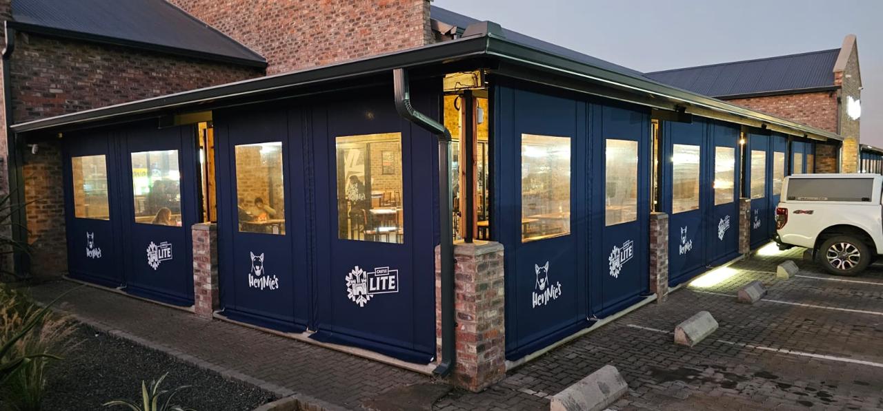 Branded drop-blind and awning enclosure installed at Hennie's restaurant